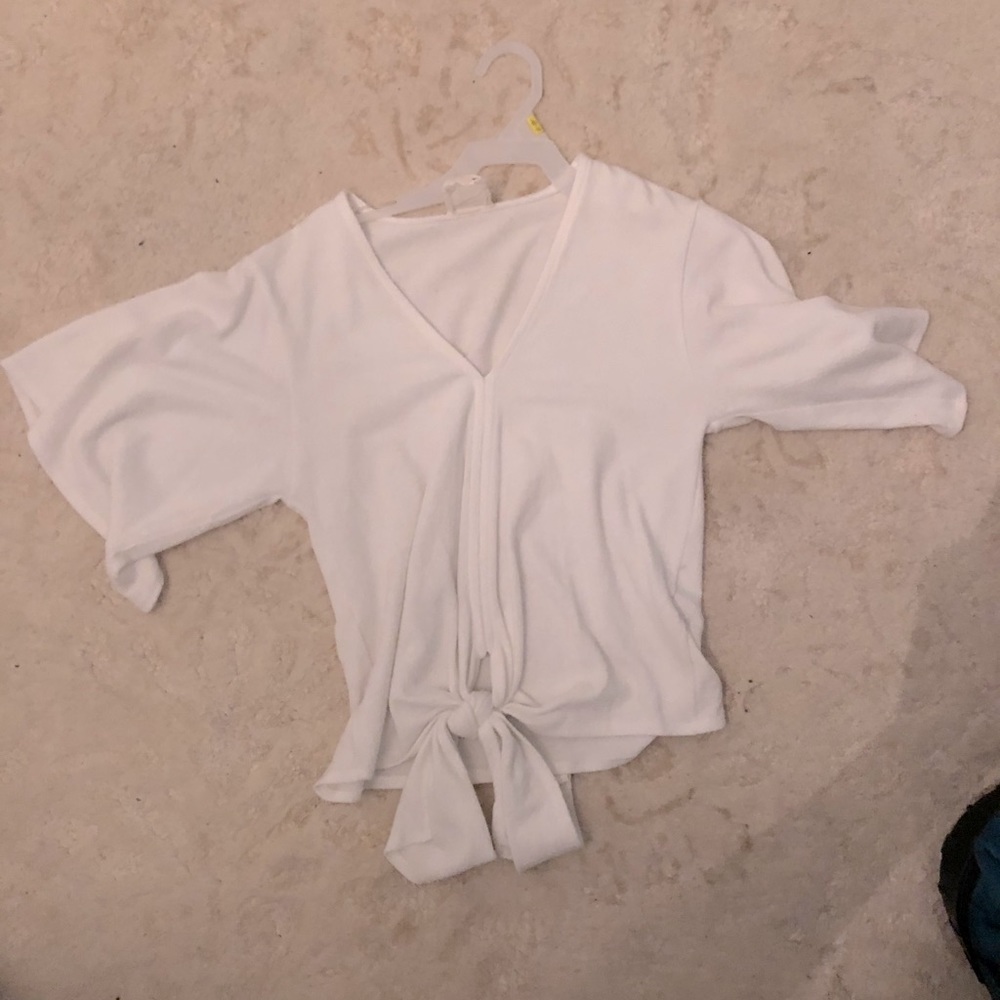 White flowy shirt with knot in the front.